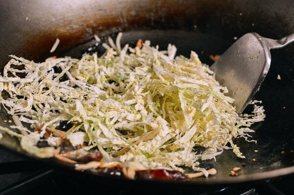 Adding shredded cabbage to wok, by bmeteor.aiodimecu.cf