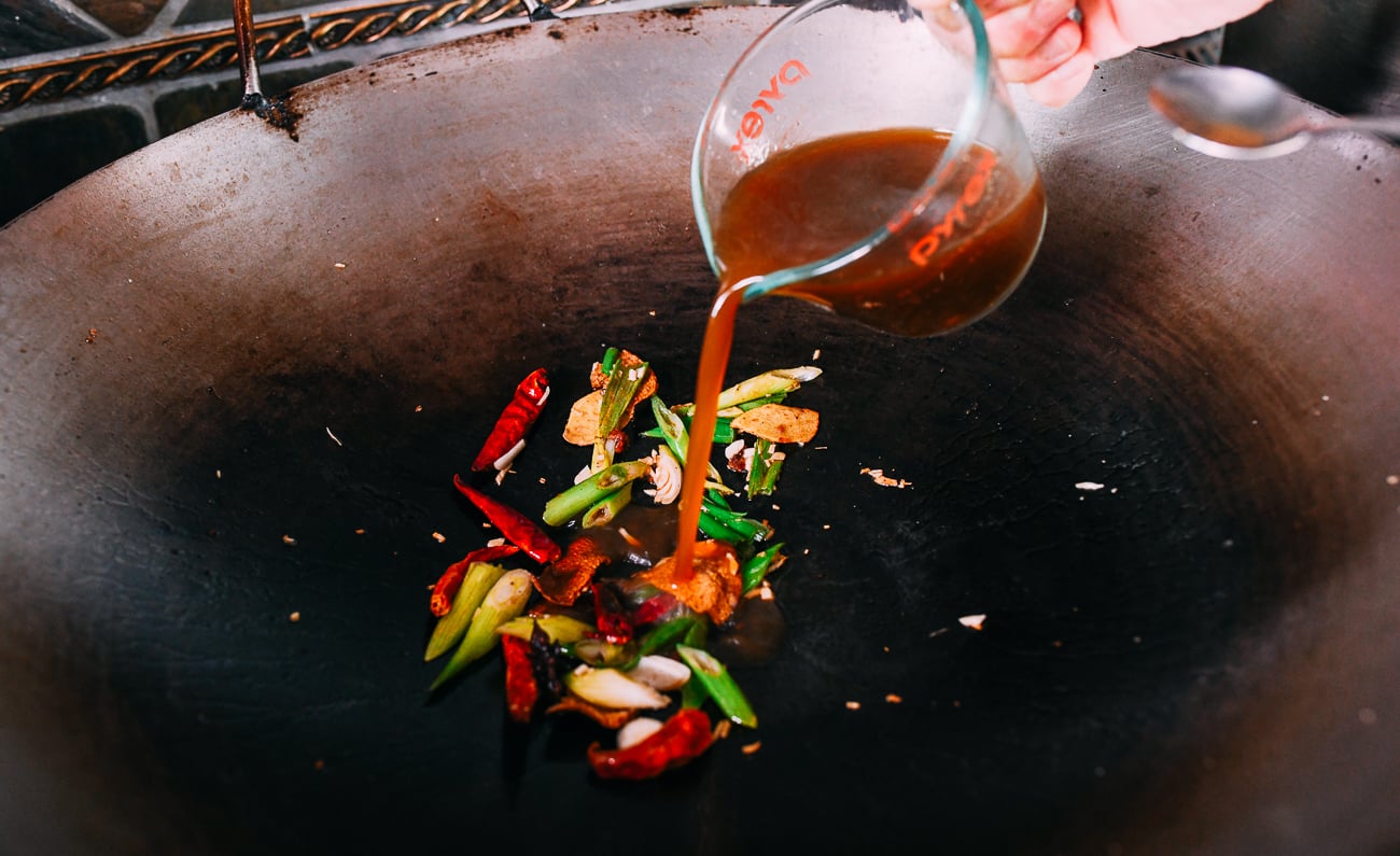 Adding sauce mixture to aromatics in wok