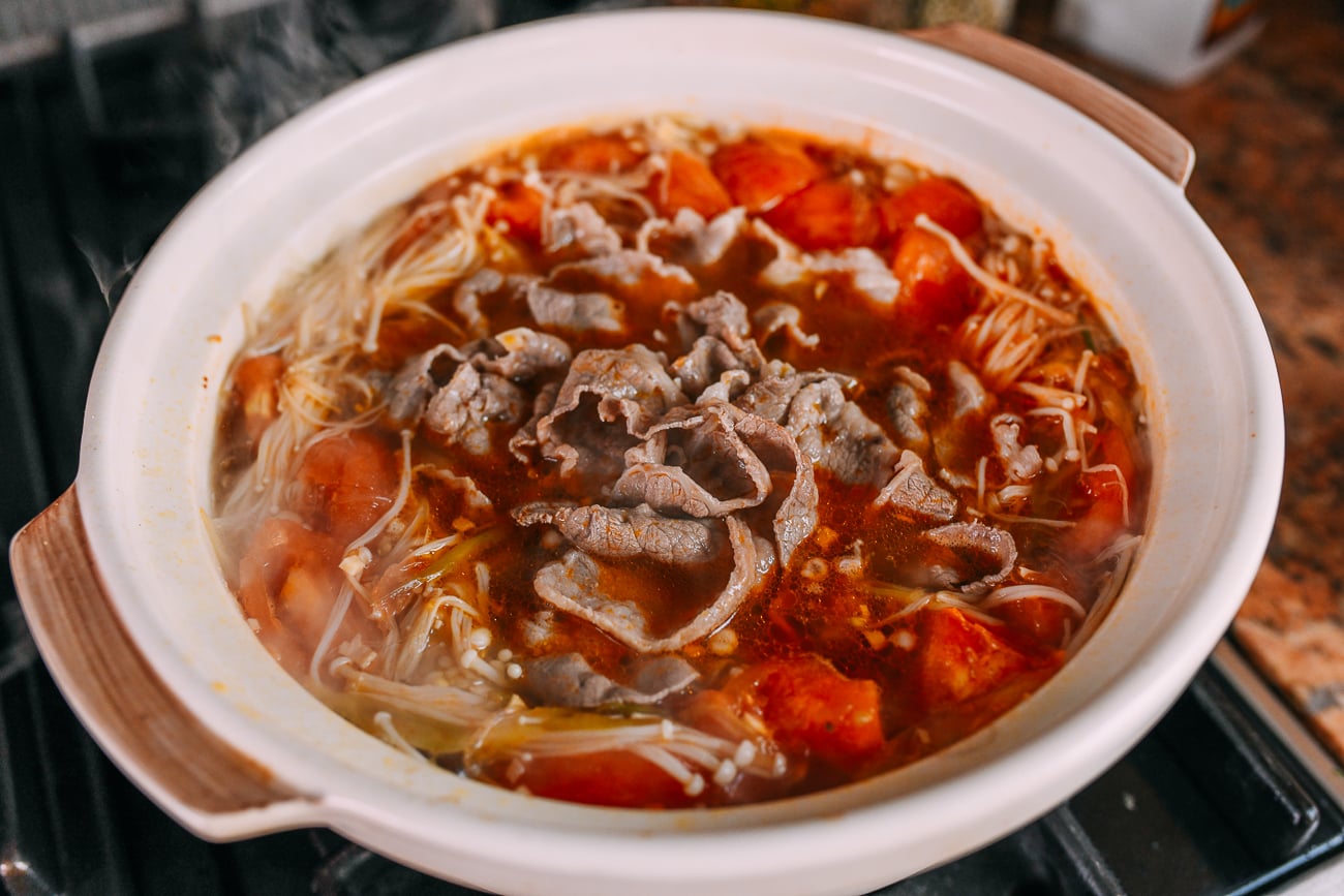 Adding hot beef to the tomato soup base