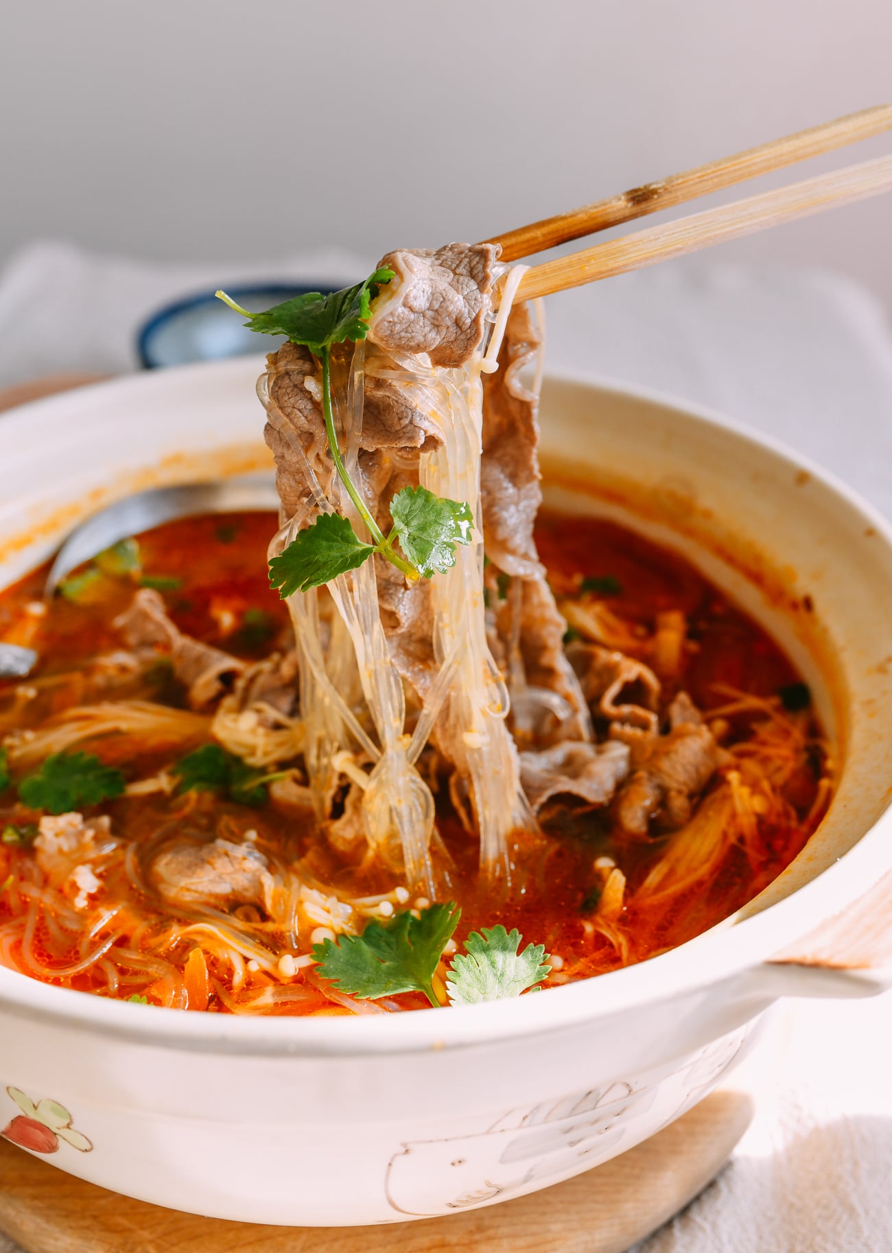 Pulling beef and mung bean noodles out of tomato beef soup