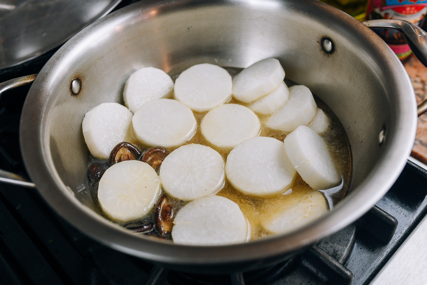 daikon radish slices and mushrooms in pot